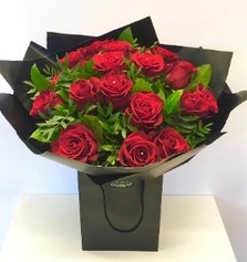 Eighteen luxury red Freedom roses, hand-tied in water, wrapped in modern cellophane, and presented in a signature black gift bag, with diamante rose centres for added sparkle.