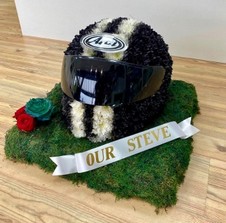 3D motorbike helmet-shaped funeral tribute made from flowers, with optional real or laminated visor, custom colours, and personal detailing such as roses or ribbon name tag.