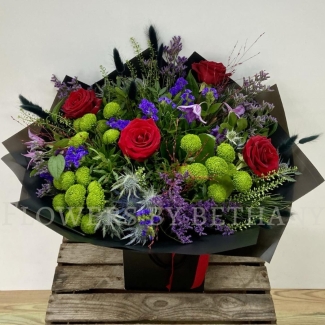 Elena bouquet with red roses, lime green blooms, purple flowers and thistle blue, hand-tied in black wrap.